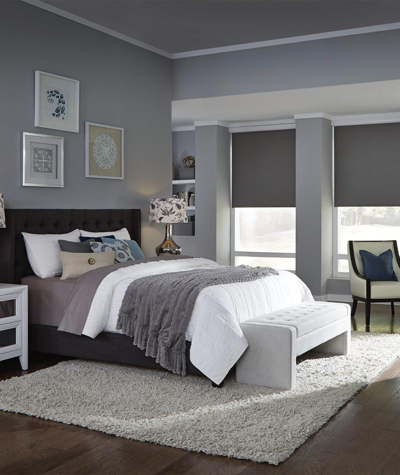 Automated Lutron shades in a modern bedroom painted in soothing greys